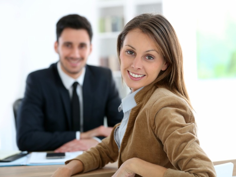 Eine Mitarbeiterin und ein Mitarbeiter sitzen an einem Besprechungstisch im Büro